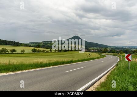 Strada di campagna nel paesaggio vulcanico Hegau con vista sul Hohenhewen, Weiterdingen, Baden-Wuerttemberg, Germania Foto Stock