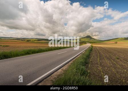 Strada di campagna nel paesaggio vulcanico Hegau con vista sul Hohenhewen, quartiere di Costanza, Baden-Wuerttemberg, Germania Foto Stock