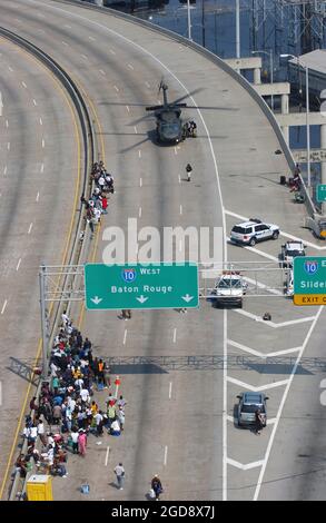 Un elicottero MH-60 Black Hawk dell'esercito statunitense atterra sulla superstrada vicino all'incrocio dell'Interstate Highway-10 per Baton Rouge e Slidell Louisiana (LA), per evacuare i residenti sfollati dall'area di New Orleans colpita dalla devastazione dell'uragano Katrina. Migliaia di sfollati residenti sono stati ricollocati in rifugi temporanei attraverso gli Stati Uniti. (FOTO USAF DI MSGT SCOTT REED 050903-F-4884R-124) Foto Stock