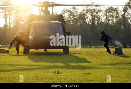 US Army (USA) personale della Guardia Nazionale scaricare pasti pronti a mangiare (MRE) da un elicottero USA UH-60A Black Hawk (Blackhawk) a Deweyville, Texas (TX). L'esercito contribuisce alle operazioni di assistenza umanitaria dell'uragano Rita nell'ambito della Joint Task Force (JTF) Rita, guidata dall'Agenzia federale per la gestione delle emergenze (FEMA) in collaborazione con il Dipartimento della Difesa (DOD). (FOTO USAF DI SSGT JACOB N. BAILEY 050926-F-5964B-375) Foto Stock