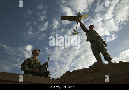 US Army (USA) Specialist Fourth Class (SPC) Ted Trenary (sinistra), e USA Private First Class (PFC) Kevin Tirserio, 101st Airborne Division (ad), Fort Campbell, Kentucky (KY), si preparano a lanciare un veicolo aereo Raven senza equipaggio (UAV) dalla Forward Operations base (FOB) McHenry, Iraq, durante l'operazione DI LIBERTÀ IRACHENA. I soldati voleranno il Raven sul percorso Trans-am per cercare dispositivi esplosivi improvvisati (IED). (FOTO USAF DI TSGT ANDY DUNAWAY 051130-F-2828D-022) Foto Stock