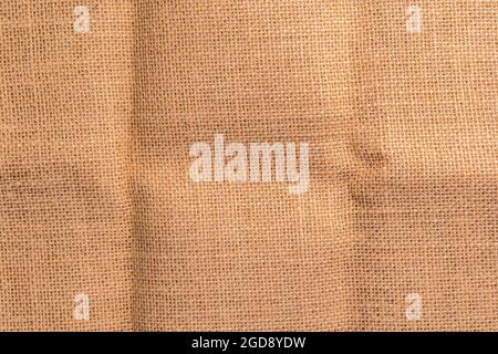 Ruvido rustico sackcloth trama crumpled sfondo. Spazio di copia. Materiale naturale piegato e cremoso. Sfondo astratto Foto Stock