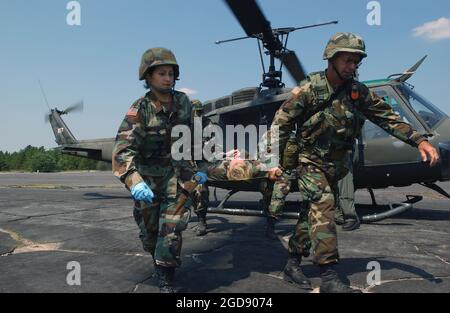 US Army (USA) personale medico trasportano un paziente trasportato da una barella da un elicottero UH-1 Iroquois Huey Air Ambulance degli Stati Uniti, parcheggiato sulla linea di volo a Fort Gordon, Georgia (GA), come partecipano all'esercizio GOLDEN MEDIC 2006, Che è un esercizio annuale di formazione medica che coinvolge tutto il personale medico delle quattro filiali dei servizi armati degli Stati Uniti. Quest'anno si tratta di un esercizio congiunto delle forze aeree USA e USA (USAF). (FOTO USAF DI SRA JACQUELINE KABLUYEN 060617-F-2114K-083) Foto Stock