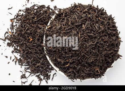 Foglie di tè Assam essiccato su sfondo bianco. Foto Stock