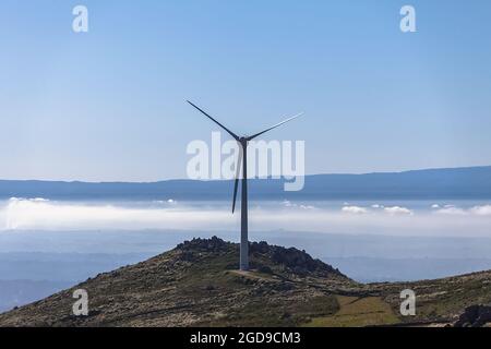 Splendida vista dalla cima del Caramulo sulle montagne della Serra da Estrela, turbine eoliche e rocce granitiche, sottobosco a Viseu, Portu Foto Stock