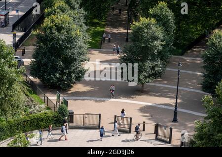 Visto dall'elevazione dal Marble Arch Mound, gli utenti del parco camminano attraverso Speakers Corner, all'angolo nord-orientale di Hyde Park, l'11 agosto 2021, a Londra, Inghilterra. Foto Stock