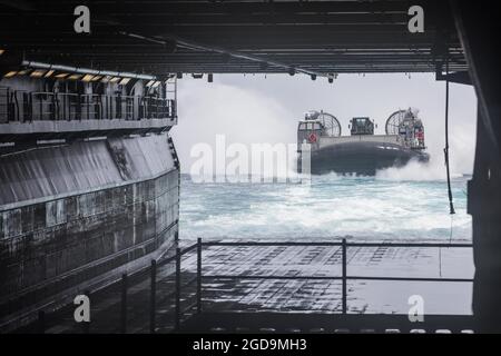 Un'imbarcazione di atterraggio della Marina degli Stati Uniti, cuscino d'aria (LCAC) ritorna alla nave d'assalto anfibia di Wasp-Class USS Kearsarge (LHD 3) in preparazione all'esercizio su larga scala (LSE) 2021, a bordo della USS Kearsarge, 2 agosto 2021. LSE 2021 dimostra la capacità della Marina di impiegare una forza precisa, letale e schiacciante a livello globale in tre comandi di componenti navali, cinque flotte numerate e 17 fusi orari. LSE 2021 unisce le capacità di formazione live e sintetica per creare un ambiente di formazione robusto e intenso. Collegherà la formazione ad alta fedeltà e le operazioni del mondo reale, per sviluppare le conoscenze e le competenze necessarie Foto Stock