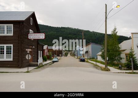 Una tipica strada non asfaltata, intersezione con legno vecchio, edifici tradizionali. A Dawson City, Yukon, Canada. Foto Stock