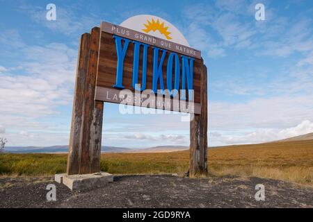 Il territorio di Yukon segno legno su un giorno luminoso, soleggiato, cielo blu. Il motto, Plus Grand Que Nature. In Canada. Foto Stock