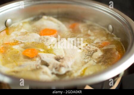 Il brodo sta bollendo in una pentola. Carne e verdure sono bollite. Foto Stock