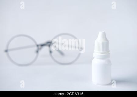 primo piano del flacone per oculari e dell'occhiale su bianco, Foto Stock