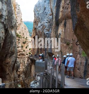 Malaga, Andalusia, Spagna. 09,03,2020. Gruppo di escursionisti con casco e maschere che camminano lungo il Caminito del Rey nella Gola di Gaitanes a Malaga. Foto Stock