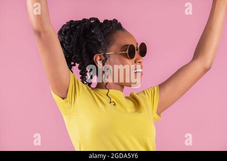 Sorridente afroamericana sollevando le braccia in festa Foto Stock