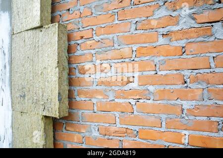 Isolamento termico della facciata di un edificio in mattoni dall'esterno. Isolamento termico di muratura con lana minerale. Isolamento termico di un hous Foto Stock