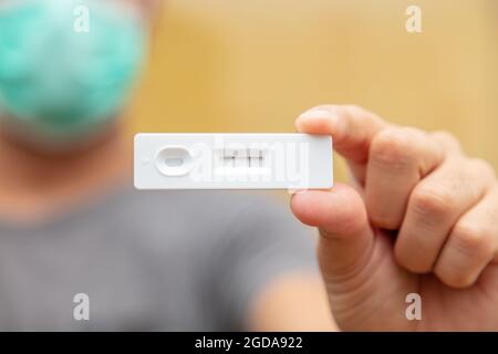 Coronavirus infettato, risultato positivo del covid 19, test di auto-test a casa, test rapido di tenuta della mano dell'uomo, kit per la rilevazione di anticorpi e immunità. Primo piano Foto Stock
