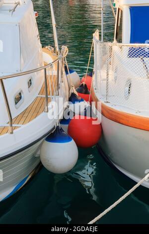 Boe tra yacht in costa marina nel porto turistico. Vacanze estive. Foto Stock