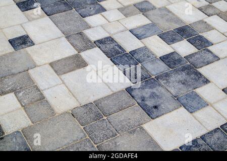 Lastre o pietre grigie per pavimentazione in calcestruzzo o pavimentazioni pavimentate di recente posa per pavimenti o passerelle. Lastre per pavimentazione in calcestruzzo nel cortile o nella pavimentazione stradale. Giardino in mattoni pa Foto Stock