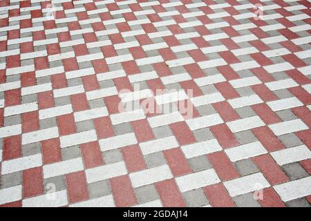 Calcestruzzo o pavimentazioni pavimentate di recente posa in grigio e rosso o pietre per pavimenti o passerelle. Lastre per pavimentazione in calcestruzzo nel cortile o nella pavimentazione stradale. Giardino Foto Stock
