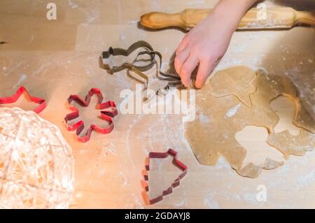 Le mani dei bambini fanno i biscotti di Capodanno dello zenzero.Preparazioni per Natale Foto Stock