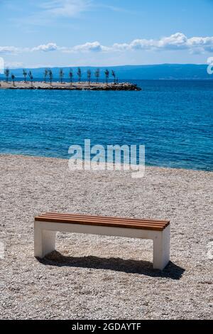 Spiaggia di Trstenik a Spalato, Croazia. Un banco vuoto che guarda fuori sopra l'alloggiamento. 2021 Foto Stock