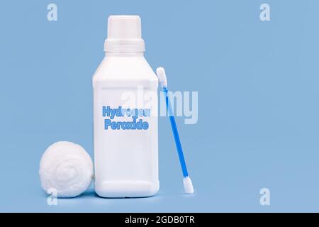 contenitore di plastica, flacone di medicina, scritto in inglese: perossido di idrogeno, fondo blu isolato, concetto di prima cura Foto Stock