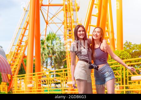 donne happy smile viaggio nel parco divertimenti divertimento godere ritratto sorridente con gli amici in parchi a tema stagione estiva outdoor background. Foto Stock