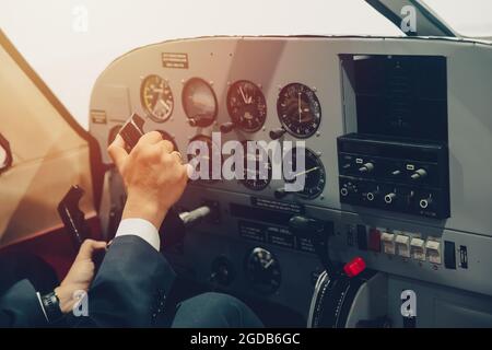 Pilota a mano o capitano di volo privato aereo di controllo con molti aeromobili calibro nel cruscotto abitacolo. Foto Stock