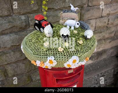 Una scena rurale lavorata a maglia 'cappello' sulla parte superiore di una scatola postale a Hawes, nello Yorkshire Dales National Park, Regno Unito. Foto Stock