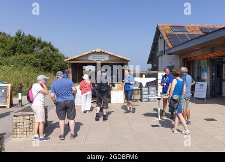 Il personale della RSPB accoglie i visitatori all'ingresso della RSPB Bempton Cliffs, East Yorkshire UK, in una giornata di sole in estate Foto Stock