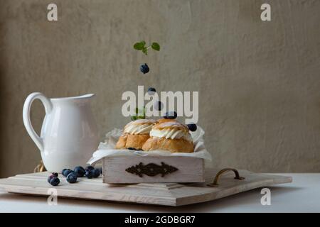 Panini tradizionali fatti in casa al forno al tavolo per la colazione, pane tradizionale svedese semola per il giovedì della Grova Foto Stock