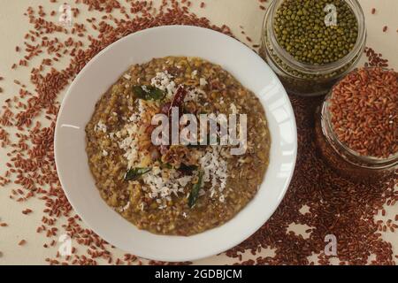 Porridge o gruel a base di riso Navara, fagioli mungs e semi di fieno cosparsi di cocco fresco grattugiato. Conosciuto anche come navara kichadi o uluva kanji Foto Stock