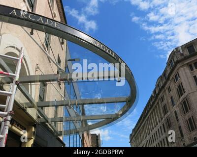 Gli acquirenti di Argyle Street si riflettono nel tetto in vetro che si trova all'ingresso dell'Argyll Arcade, il quartiere dei gioielli di Glasgow, in un passaggio coperto. Foto Stock