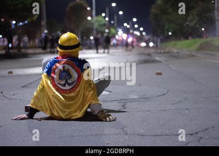 Bogotà, Colombia. 11 Agosto 2021. Un dimostratore di prima linea usa la bandiera colombiana mentre aumentano gli scontri tra i dimostranti e la polizia in rivolta della Colombia (ESMAD) nel nord di Bogotà, Colombia, adnista lo sfratto e la deforestazione di una riserva naturale il 11 agosto 2021. Credit: Long Visual Press/Alamy Live News Foto Stock