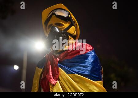 Bogotà, Colombia. 11 Agosto 2021. Un dimostratore di prima linea usa la bandiera colombiana mentre aumentano gli scontri tra i dimostranti e la polizia in rivolta della Colombia (ESMAD) nel nord di Bogotà, Colombia, adnista lo sfratto e la deforestazione di una riserva naturale il 11 agosto 2021. Credit: Long Visual Press/Alamy Live News Foto Stock