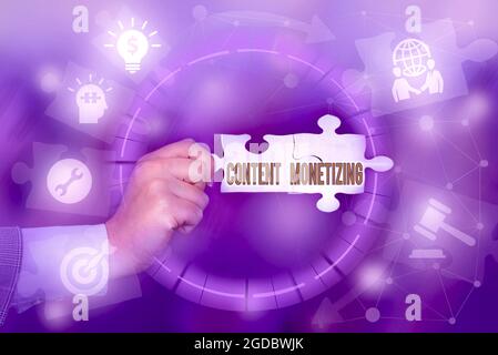 Scrittura visualizzazione del testo monetizzazione del contenuto. Idea di affari che fa i soldi dal soddisfare che esiste sul vostro pezzo di puzzle di Jigsaw di tenuta di mano di Web site Foto Stock