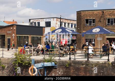 Hull Waterfront; persone che si siedono a bere nei caffè e fuori nel sole estivo, Hull Waterfront e Marina, Hull Yorkshire Regno Unito Foto Stock