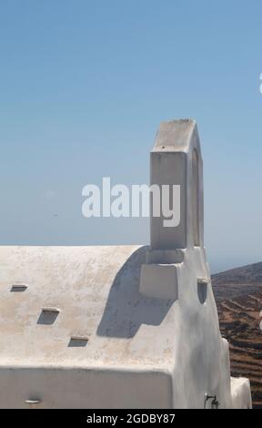 Grecia, l'isola di Sikinos. Una vista ravvicinata di una vecchia cappella nel cuore della capitale delle isole, l'Hora. Ombre dal campanile. Foto Stock