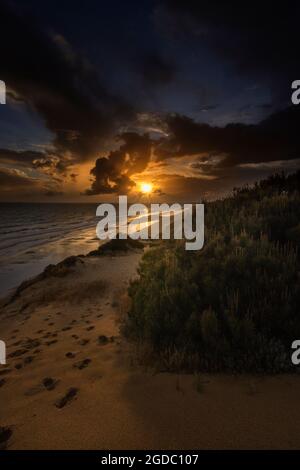 Vista sulla splendida spiaggia di Mazagon, situata nella provincia di Huelva, Spagna. Con le sue scogliere, pini, dune, vegetazione verde e un cielo Foto Stock