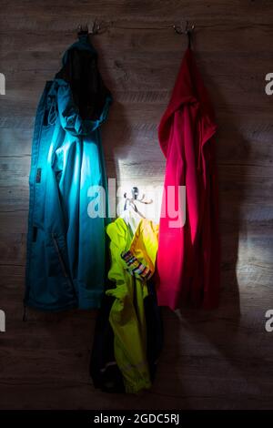 Camici colorati appesi su appendiabiti illuminati con raggi solari Foto Stock