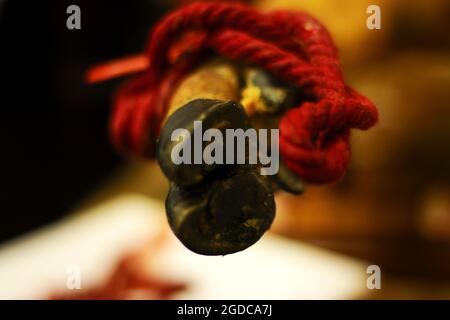 Dettaglio di zoccoli di maiale iberico con gamba nera con corda rossa Foto Stock