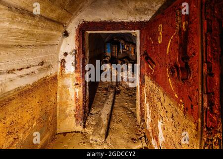 Porta armata in metallo arrugginito nel vecchio bunker sovietico sporco abbandonato. Foto Stock