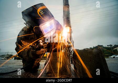 U.S. Marine Corps Sgt. Shane Holum, ingegnere di combattimento con sede centrale e Battaglione di supporto, Marine Corps Installations Pacific – Marine Corps base Camp Smedley D. Butler, salda una recinzione il 4 dicembre 2020, su Camp Foster, Okinawa, Giappone. Holum è un nativo di Fall Creek, Wisconsin. (STATI UNITI Marine Corps foto di CPL. Brennan J. Beauton) Foto Stock