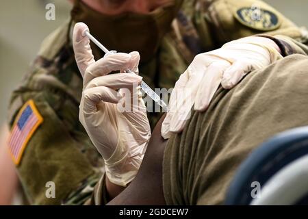 SPC. Victoria Yarborough, specialista in assistenza sanitaria per il distaccamento medico della Guardia Nazionale del Maryland, amministra un vaccino COVID-19 ad un Soldato l'8 gennaio 2021, presso la riserva militare Camp Fretterd, Reisterstown, MDNG Soldiers e Airmen stanno sostenendo l'iniziativa di vaccinazione COVID-19 del Maryland con squadre di supporto per la vaccinazione mobile, Che forniscono supporto medico e logistico ai dipartimenti sanitari della contea durante la pandemia globale COVID-19. (STATI UNITI Air National Guard foto di staff Sgt. Sarah M. McClanahan) Foto Stock