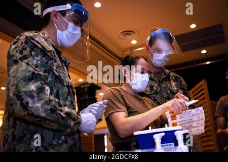 U.S. Navy Hospitalmen con U.S. Naval Hospital Okinawa, preparare il vaccino COVID-19 a Camp Hansen, Okinawa, Giappone, 21 gennaio 2021. Questa è stata la seconda distribuzione del vaccino sul Camp Hansen da quando il Dipartimento della Difesa degli Stati Uniti ha iniziato a somministrarlo ai membri del servizio a Okinawa, il 27 dicembre 2020. (STATI UNITI Corpo marino foto di Sgt. Audrey M. C. Rampton) Foto Stock