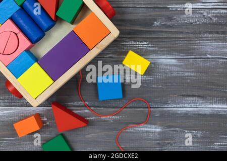 Grande e colorato kit da costruzione in legno su un legno. Ritorno a scuola, giochi per asilo, istruzione prescolare. Foto Stock