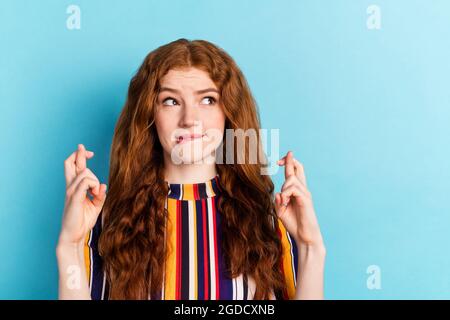 Foto di preoccupato arancio hairdo millennial lady barrette incrociate guardare spazio vuoto indossare camicia colorata isolato su sfondo di colore blu Foto Stock