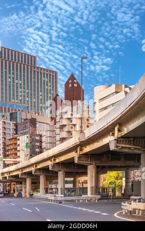tokyo, giappone - luglio 05 2021: Shuto Expressway nel quartiere di Shimbashi con l'iconico edificio della Torre della capsula di Nakagin sormontato da una ruggine sul tetto Foto Stock