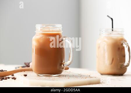 Tavola con vasetti di mason di gustoso caffè ghiacciato sul tavolo Foto Stock