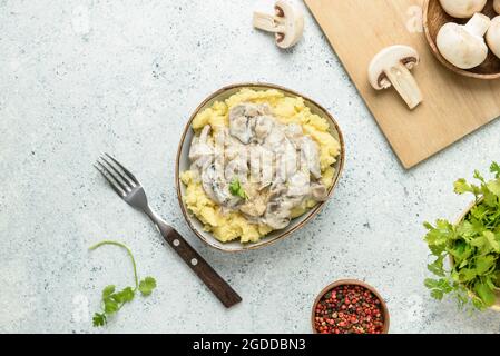Ciotola con gustosi purè di patate, funghi e peppercorn sul tavolo Foto Stock
