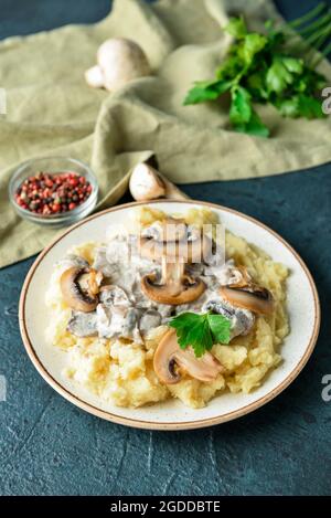 Piatto con gustosi purè di patate, funghi e peppercorn su sfondo colorato Foto Stock